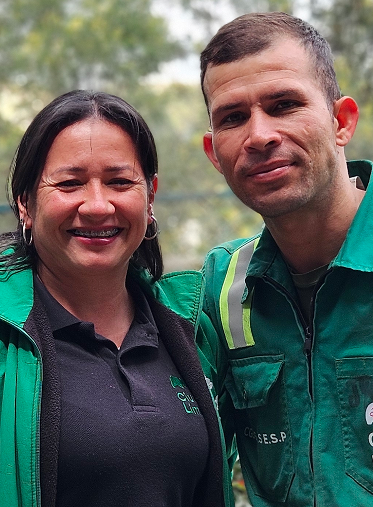 Dos colaboradores de Ciudad Limpia posando sonrientes al aire libre, en un retrato cercano que refleja cercanía y trabajo en equipo.