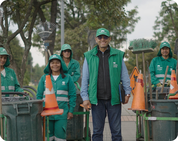 Equipo de Ciudad Limpia posando en un espacio público junto a carros de barrido, herramientas de limpieza y señalización vial, durante una jornada operativa.