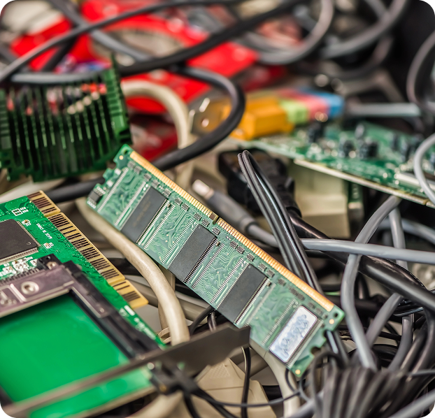 Primer plano de residuos electrónicos compuestos por memorias RAM, tarjetas de circuito, cables y otros componentes de computador apilados entre sí. La imagen muestra materiales tecnológicos en desuso dentro de un proceso de recolección o gestión de RAEE.